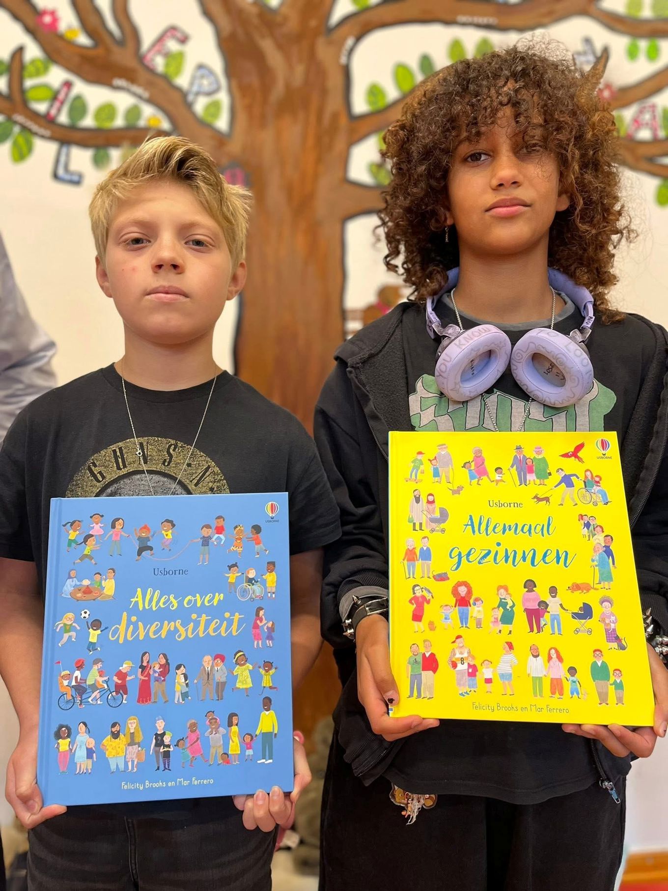 To elever som holder hver si bok om familier og mangfold.