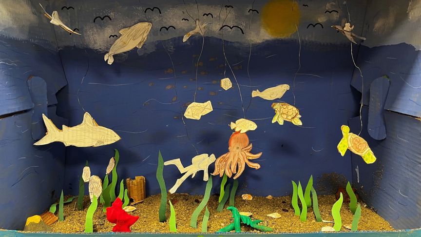 Et diorama lagd i en pappeske. Dioramaet viser livet i havet med planter, fisk og andre sjødyr.