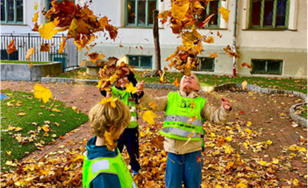 Foto: Elisabeth Wiik Et par barn som leker i en skolegård med løv på bakken.