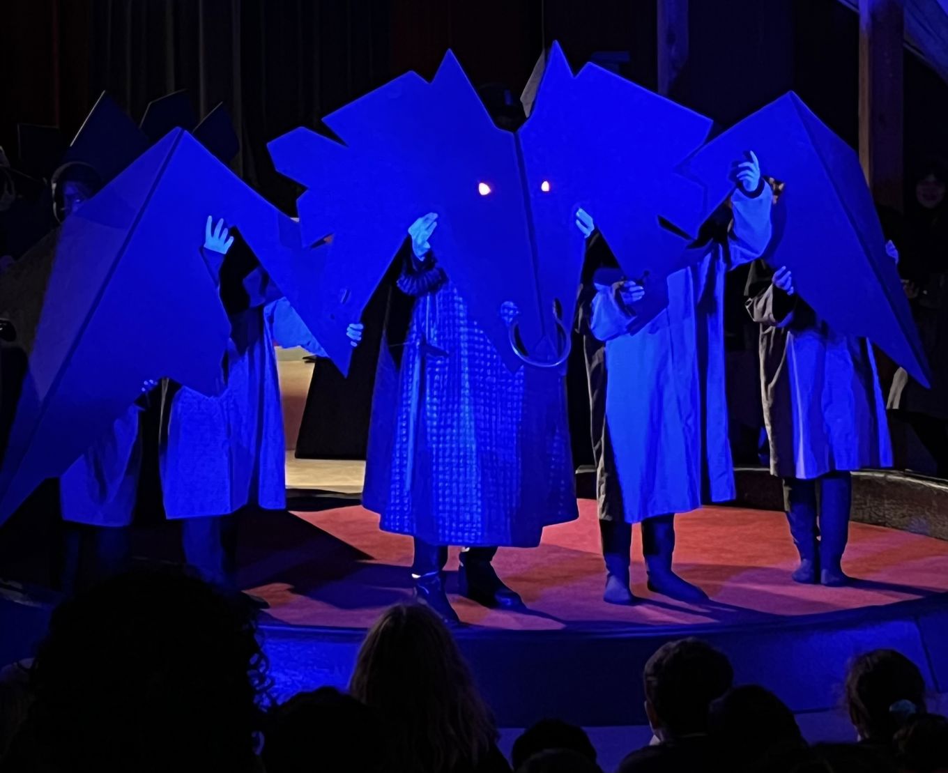 Ei gruppe barn som opptrer på en scene. De skaper en drage.