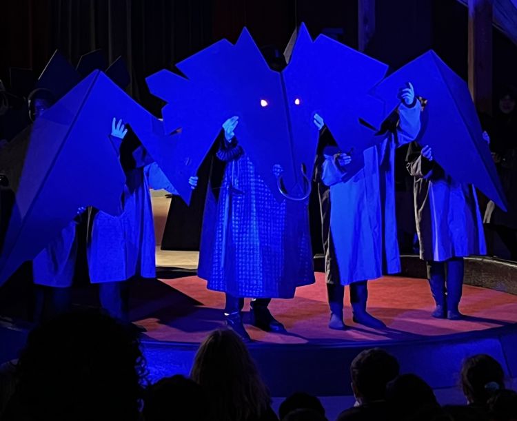 Ei gruppe barn som opptrer på en scene. De skaper en drage.