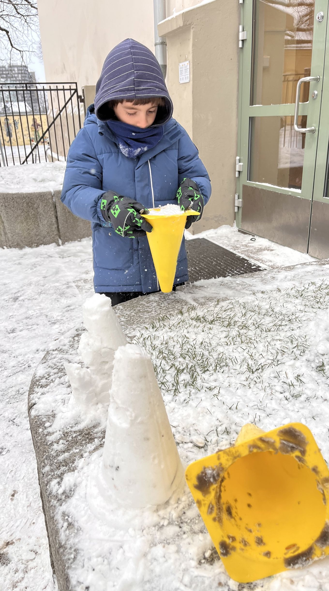 et barn som lager tårn av snø