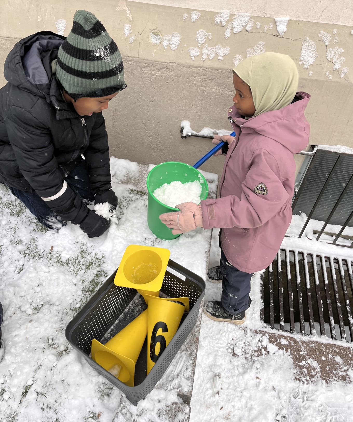 Et par barn som leker i snøen