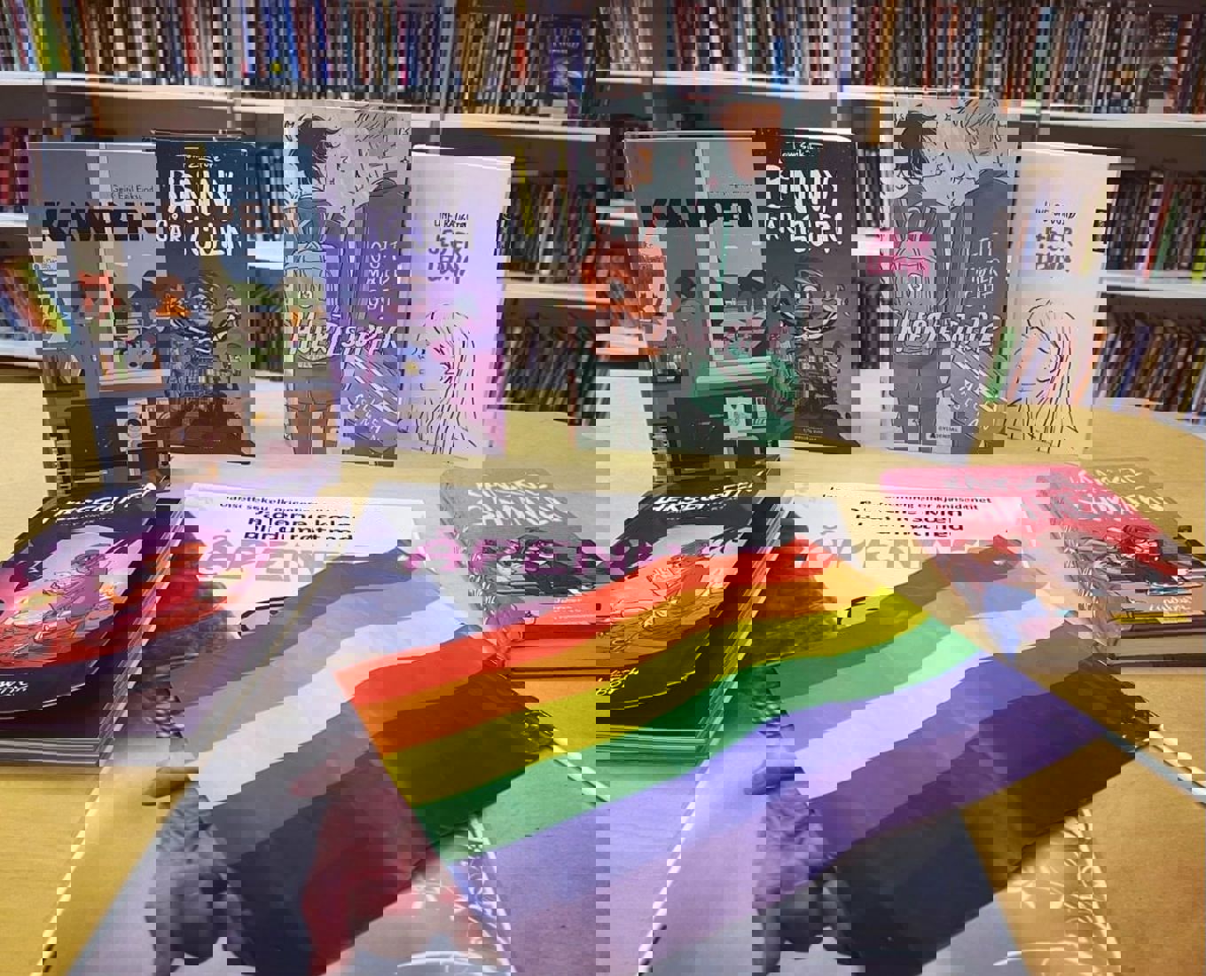 Bøker og regnbueflagg på skolebiblioteket.