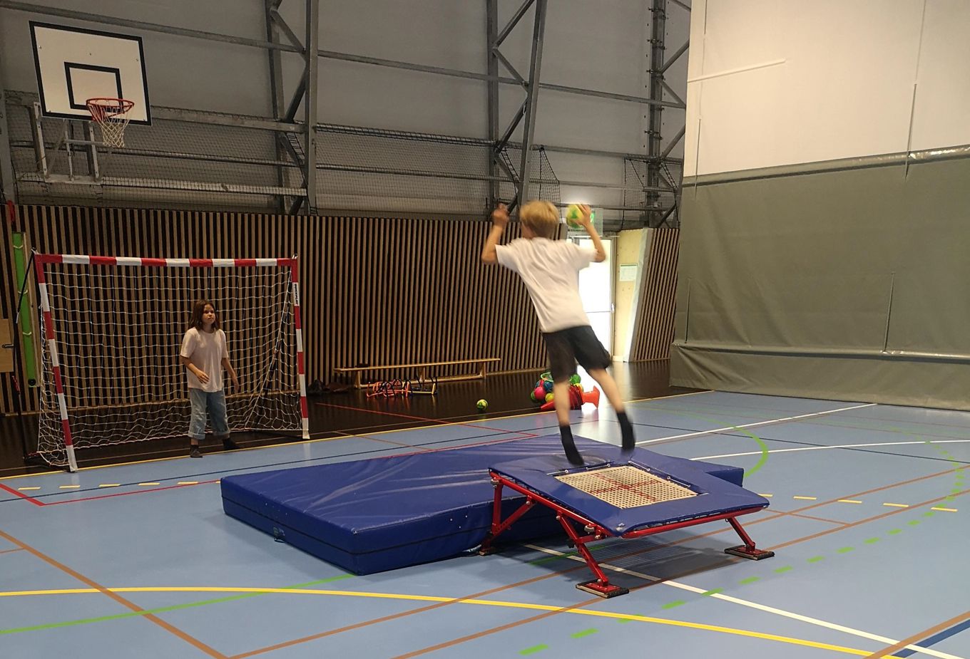 Håndball. Gutt som hopper på trampoline og øver på å skyte mål..