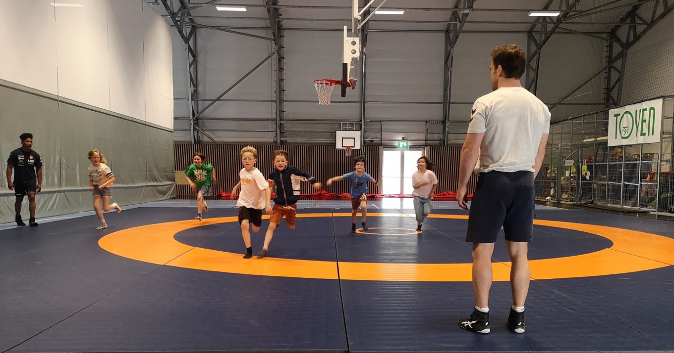 Idrettshall. Barn som kommer løpende mot fotografen.