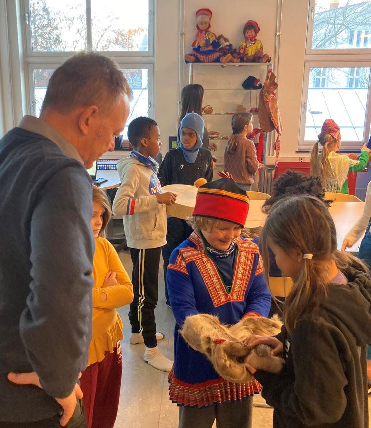 Elever fra Gamlebyen skole i et klasserom ved  Oslo samiske skole. Elevene prøver kofter og andre klesplagg.